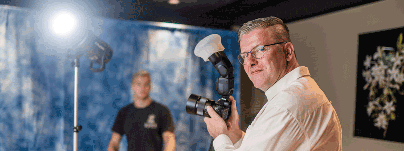 Student Hans als beroepsfotograaf met camera in de hand